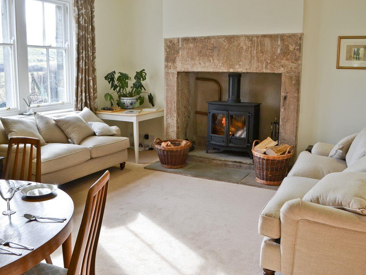 Sitting room with original fireplace and modern woodburning stove.